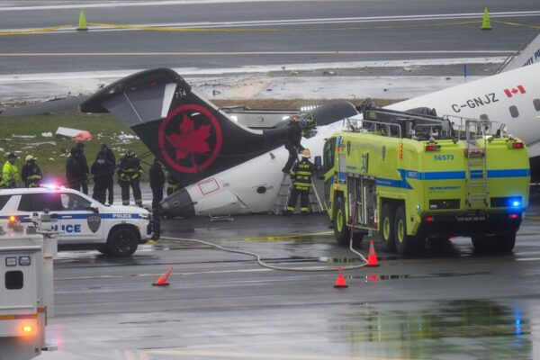 Bombeiros e investigadores examinam o local, na segunda-feira, 23 de março de 2026, onde um avião da Air Canada parou após colidir com um caminhão de bombeiros